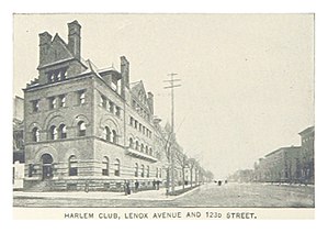 Four-story stone building on the left, unpaved street on the right