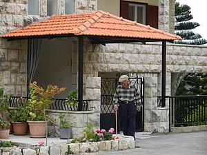 A man walking out his house in Ejdabrine, Koura, Lb.jpg