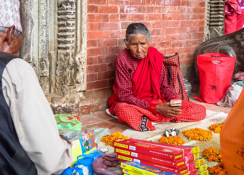 File:An old woman selling pooja materials to earn a living.jpg