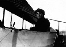 Photographie en noir et blanc d'un homme à bord d'un avion en métal.