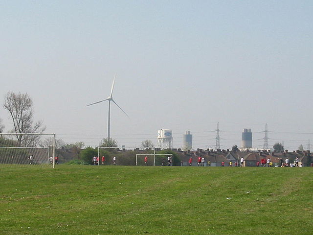 The southern Dagenham skyline includes structures of the Ford plant and wind turbines.