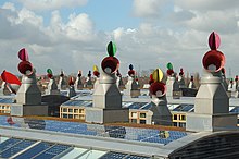 BedZED (Beddington Zero Energy Development), the UK's largest and first carbon-neutral eco-community: the distinctive roofscape with solar panels and passive ventilation chimneys BedZED roofs 2007.jpg