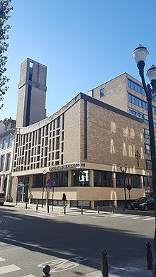 A picture of the church building from the street. The corner angle shows the gentle sweep of the brick facade and tower.