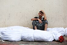 Palestinian man with body bags in Jabalia refugee camp Damage in Gaza Strip during the October 2023 - 18.jpg