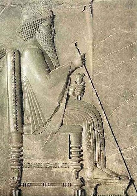 Relief carving of Darius the Great of Persia on his throne, holding a sceptre and lotus