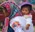 Indigenous mom from Ecuador with her traditional babywearing.png