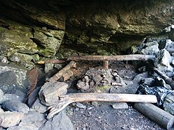 En grillplats med stockar som bänkar runtom i en grotta som heter Jättstugan.