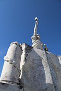 A gauche un obus entouré d'une guirlande de laurier.