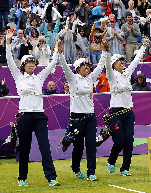 Ki (left) celebrates her 2012 gold medal win in the women's team event with Lee Sung-jin (centre) and Choi Hyeon-ju (right)