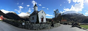 Loen kirke med bygninger fra det gamle Loentunet bak. Foto: Fortegnet panoramabilde våren 2015