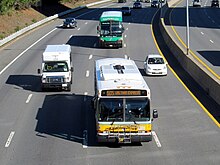 A route 505 bus on the Mass Pike MBTA route 505 bus, Peter Pan bus, and The Ride bus on the Mass Pike, October 2016.JPG