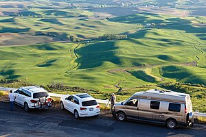 Tourists and photographers park alongside the access road