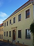 Façade of the western eaves side as the remains of a former residential building in closed development