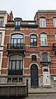 Au no 11 : maison éclectique de deux niveaux de composition asymétrique, sous mansarde, architecte Fernand Conard, 1910. Façade de briques rouges, rehaussée de briques blanches et de pierre bleue[6].