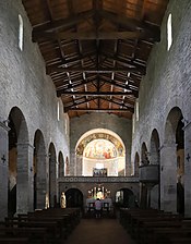 Nef d'église sous charpente de bois, à bas-côté romans.