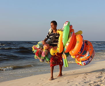 Teenager selling rubber toys on a beach in Alexandria, Egypt.