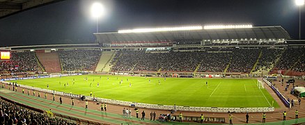 Vedere interioară a unui stadion de fotbal în timpul unui meci de noapte