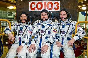 Soyuz MS-12 crew members in front of their spacecraft.jpg