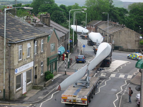 A turbine blade convoy passing through Edenfield in the U.K. (2008). Even longer 2-piece blades are now manufactured, and then assembled on-site to re