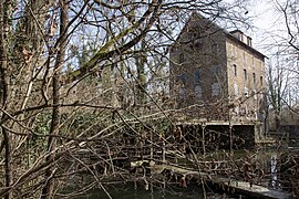 Gezicht op een oud gebouw dat dienst doet als watermolen op een eiland.