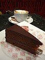 Eine Wiener Sachertorte mit einer Tasse Kaffee.