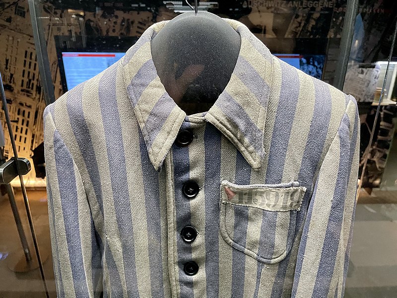 File:Auschwitz-Birkenau Konzentrations- u. Vernichtungslager German Nazi concentration extermination camp Prisoner uniform striped Red triangle political Schutzhäftling 115919 Fangedrakt Holocaust exhibition HL-senteret Oslo Norway 2021 G.jpg