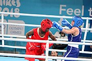 Deutsch: Boxen bei den Olympischen Jugendspielen 2018 Tag 12, 18. Oktober 2018 - Finale Fliegengewicht Mädchen – Martina La Piana (Italien, blau) schlägt Adijat Gbadamosi (Nigeria, rot) 5-0; Ringrichter ist James Beckles (Trinidad und Tobago). English: Boxing at the 2018 Summer Youth Olympics on 18 October 2018 – Girl's flyweight Gold Medal Bout - Martina La Piana (Italy, blue) beats Adijat Gbadamosi (Nigeria, red) 5-0; Referee is James Beckles (Trinidad and Tobago). Español: Boxeo en los Juegos Olímpicos Juveniles de Verano de 2018 en 18 de octubre de 2018 - Combate a medalla de oro de peso mosca para mujeres: Martina La Piana (Italia, azul) le gana a Adijat Gbadamosi (Nigeria, roja) 5-0; El árbitro es James Beckles (Trinidad y Tobago).