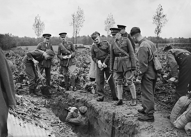 General Sir John Dill, General Officer Commanding I Corps, inspecting soldiers digging trenches at Flines, France. Stood three away from is his Brigad