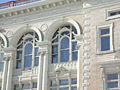 Peek-a-boo! I see you! A member of the Church of Scientology is seen on the third floor, videotaping the protesters.