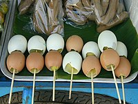 Cooked chicken eggs on a wooden stick