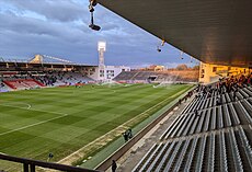 Photographie prise en haut de la tribune d'un stade de football avec en arrière-plan une tribune entière et la moitié de deux autres.