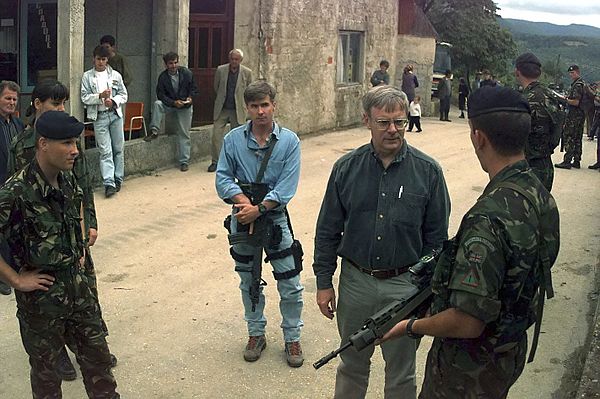 Walter B. Slocombe, the U.S. Under Secretary of Defense for Policy with his bodyguard in Bosnia and Herzegovina in 1996. The bodyguard is armed with a