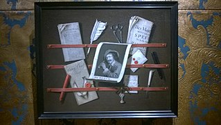 A trompe l'oeil of a letter rack with a print, a quill, sealing wax and a knife