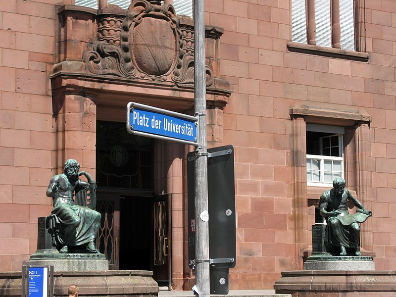 File:Eingang des Kolleggebäudes I der Uni Freiburg am Platz der Universität Homer und Aristoteles von C.jpg