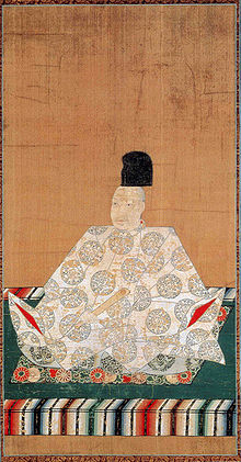 Man in keizerlijk kostuum zittend met gekruiste benen.