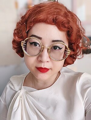 Esmé Weijun Wang with red hair and wearing a floral dress.jpg