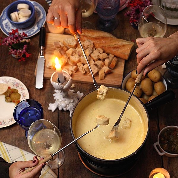 Fondue served with bread and potatoes