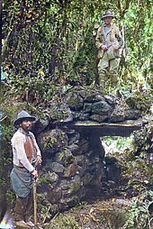 Bingham (upper right) with a local guide on a jungle bridge at Espiritu Pampa in Peru, hand-colored glass slide, 1911