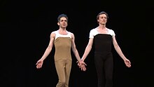 Two dancers, Ferver and Bartelme, face forward wearing chest-high dance tights and white T-shirts beneath.