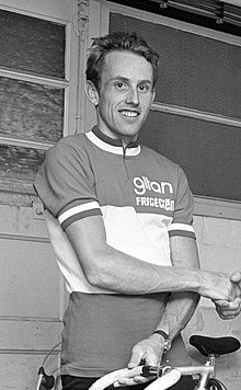 Photographie en noir et blanc d'un homme portant un maillot de cycliste et tenant le guidon d'un vélo