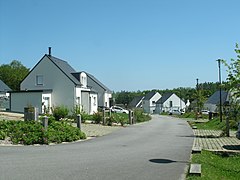 Photographie d'une rue bordée de maisons neuves.