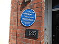 The blue plaque located at the front door of its former residence at Queens Road, Beeston.