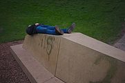 English: Man lying on the bench observing rounded inverted sky forming planet-like feeling in Hemels Gewelf, Den Haag