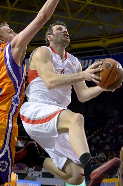 Theo Papaloukas, in white, with the ball, as an Olympiacos player, 2011.