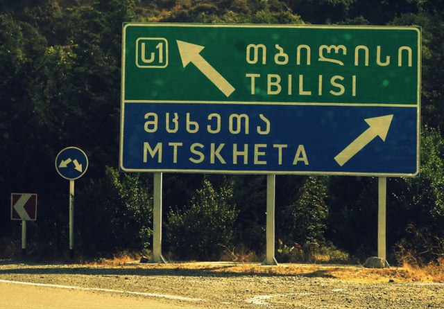 Road sign in Mtavruli and Latin scripts
