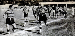 Several football players walking around in a football field