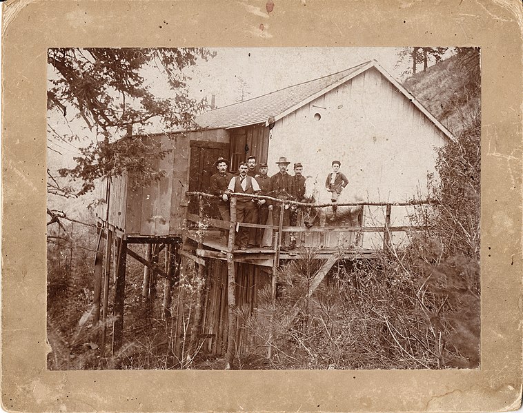 File:Several men and Mike Nee on porch of saloon near Fort Spokane. Five of the men appear to be soldiers and at least one is of the (73920124-70b9-4c05-8e85-44e037e59802).jpg