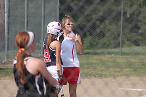 Softball-Trainerin Angie Resa bespricht den Spielplan mit einer ihrer Spielerinnen zwischen den Innings.