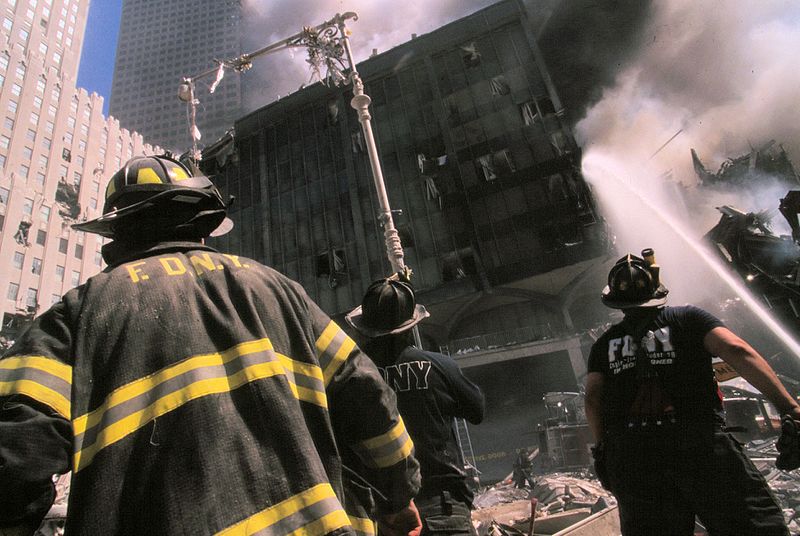 File:Three New York City fire fighters in front of burning building following September 11th terrorist attack (29318406842).jpg