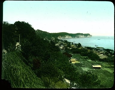 Village on a bay; fields and hillside in foreground